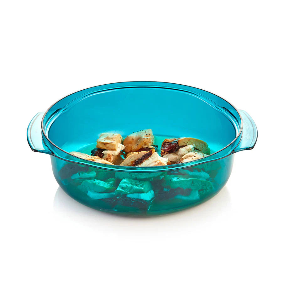 Turquoise glass baking dish with food inside on a white background