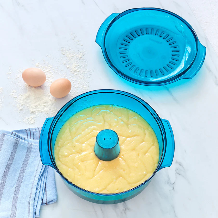 Blue kitchen containers with lids on a marble surface with eggs and flour.